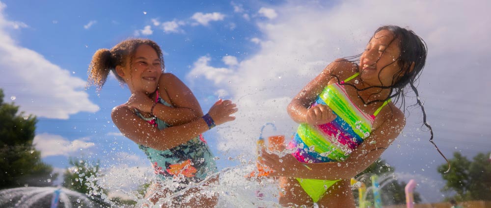young-girls-splashing-in-water Young girls splashing each other with water at the wave pool